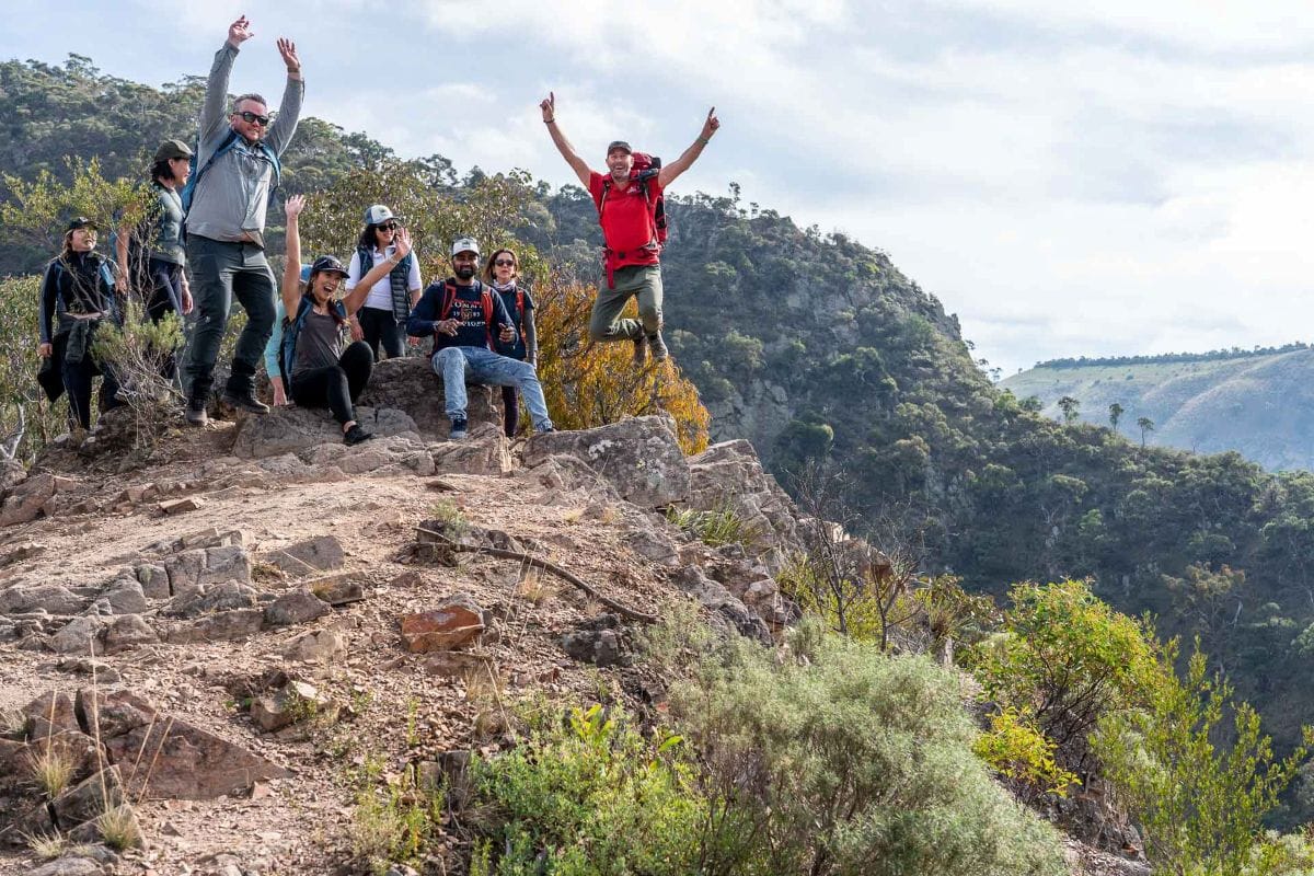 Group celebrating on a mountain edge.