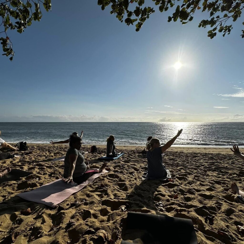 People practicing yoga on beach